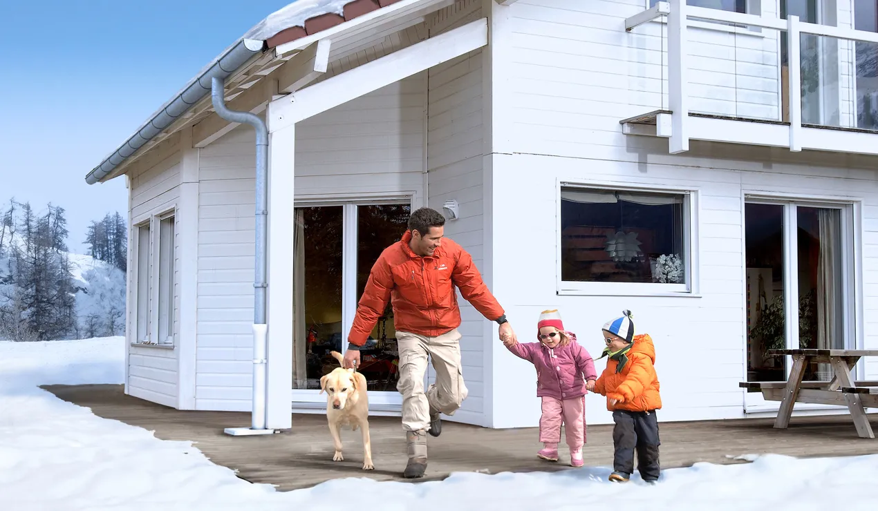 External shot of a home partially covered with snow to depict uses of gutter and pathway trace heating.
